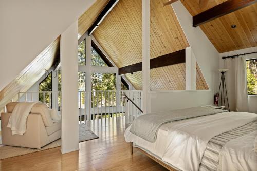 a bedroom with white walls and wooden ceilings at The Arrowhead Pearl in Lake Arrowhead