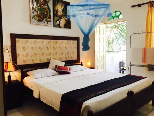 ein Schlafzimmer mit einem großen Bett und einem Fenster in der Unterkunft Holiday Nest Bed & Breakfast in Wadduwa