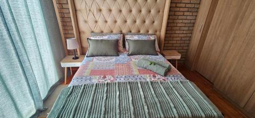 a bedroom with a large bed with a headboard and pillows at Mountain View in Klein-Brakrivier
