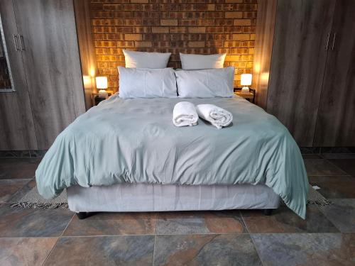 a bedroom with a bed with two towels on it at Mitchell Manor in Vryheid