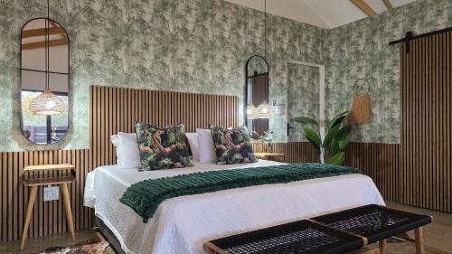 a bedroom with a large bed with a green blanket at Khaya Kwalata in Marloth Park