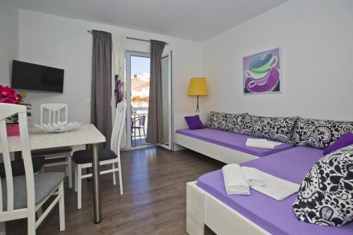 ein Wohnzimmer mit einem lila Sofa und einem Tisch in der Unterkunft Guest House Kovacevic in Hvar