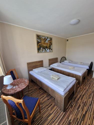 a room with two beds and a table and chairs at Centrum Noclegowe II in Bydgoszcz