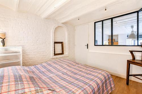 a bedroom with a bed and a window at Atelier Bleu Charmant petit Loft in Clichy