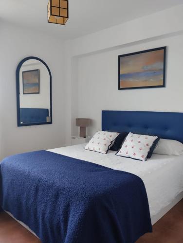 a bedroom with a blue and white bed with pillows at Frente al mar, Doña Carmen Playa, Mejor vista de Suances in Suances
