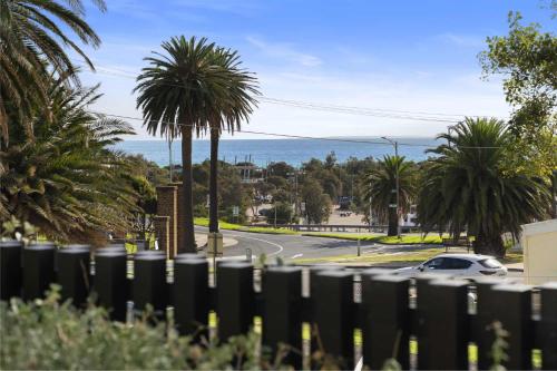 a view of a street with palm trees and the ocean at Azure Horizon - Bay Views & Rooftop Spa in Frankston