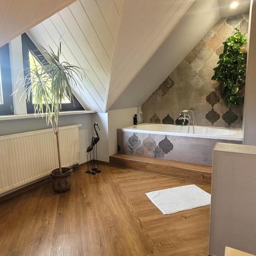 a bathroom with a bath tub in an attic at Logis Am Park in Dessau