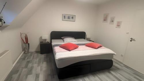 a bedroom with a bed with two pillows on it at Ferienwohnung auf dem Traumpfad in Ettringen