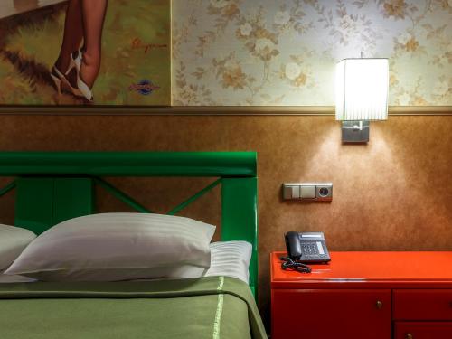a bedroom with a bed and a lamp and a phone at Road Star Hotel in Dnipro