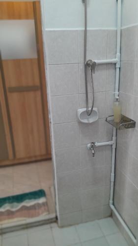 a bathroom with a shower with a candle and a door at 365house in Ban Phlu Yai