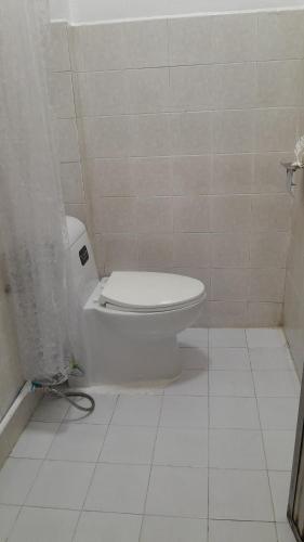 a bathroom with a toilet with a shower curtain at 365house in Ban Phlu Yai