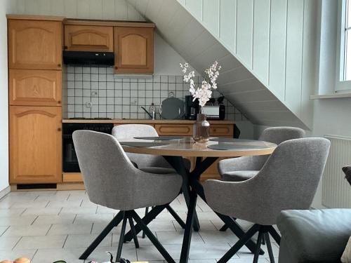 a dining room table with chairs and a kitchen at Große Auszeit in Gammendorf