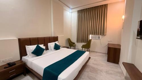 a hotel room with a bed and two chairs at Hotel Harsh Vilas-Near Tajmahal Agra in Agra