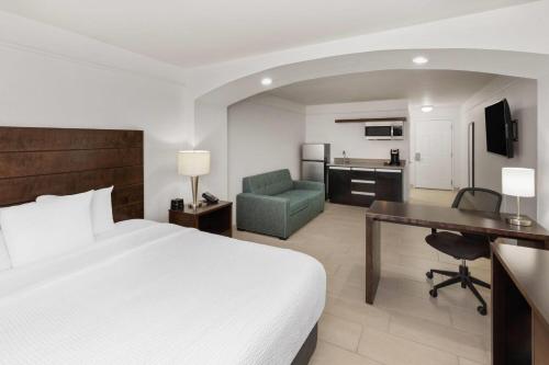 a hotel room with a bed and a desk and a chair at La Quinta by Wyndham Laredo Airport in Laredo