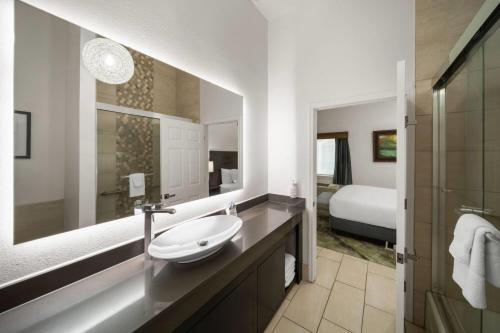 a bathroom with a sink and a large mirror at La Quinta by Wyndham Laredo Airport in Laredo