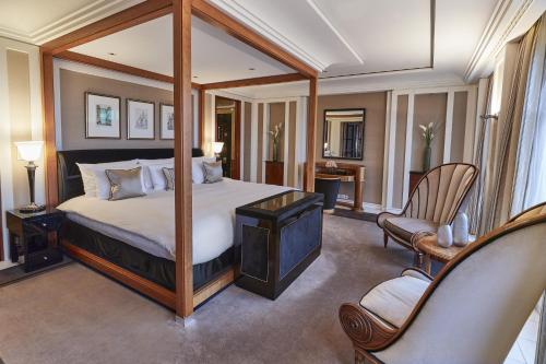 a bedroom with a canopy bed and two chairs at Hotel Adlon Kempinski Berlin in Berlin