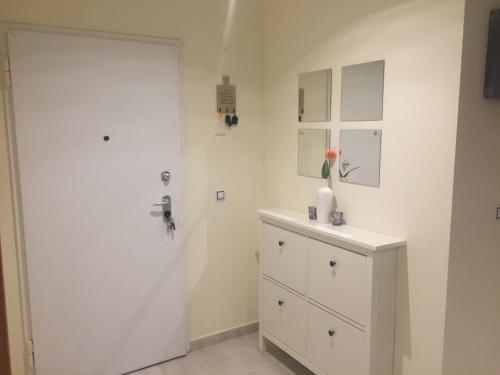 a white bathroom with a white door and a dresser at Résidence Saradon La Zenia Boulevard in Los Dolses