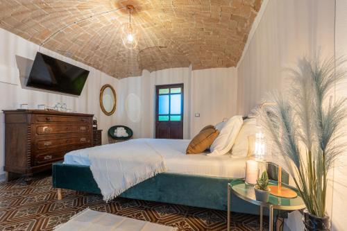 a bedroom with a bed and a tv and a table at B&B Il Podestà in Garbagna