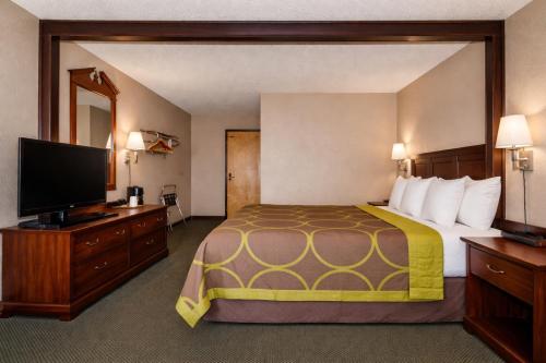a hotel room with a bed and a flat screen tv at Townhouse Super Gallup - I-40 in Gallup