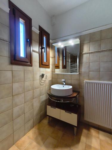 a bathroom with a sink and a mirror at Palio Dream House in Paleo Tsifliki