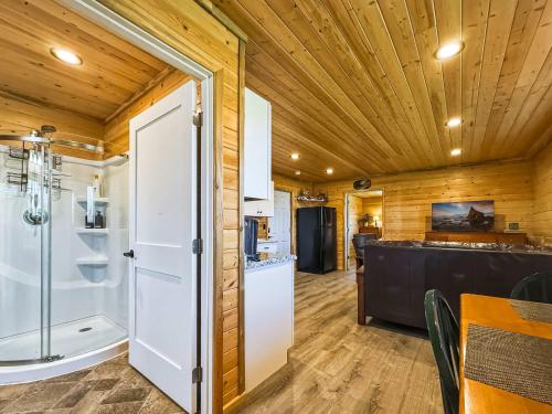 a bathroom with a shower and a kitchen with a counter at Cozy Pine Getaway in Sequim
