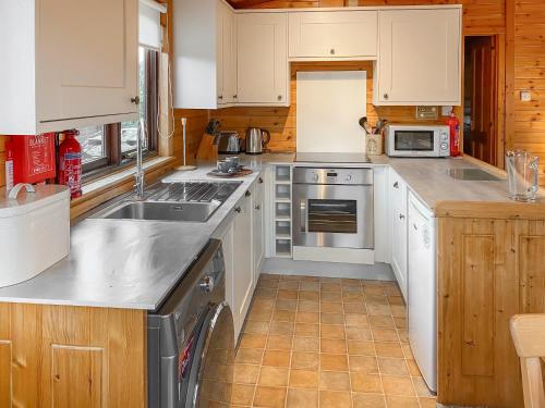 a kitchen with white cabinets and stainless steel appliances at Burnside Park in Keswick