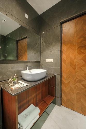 a bathroom with a sink and a mirror at Hotel Tranquil Airport Road Sector 66 Mohali Chandigarh in Mohali
