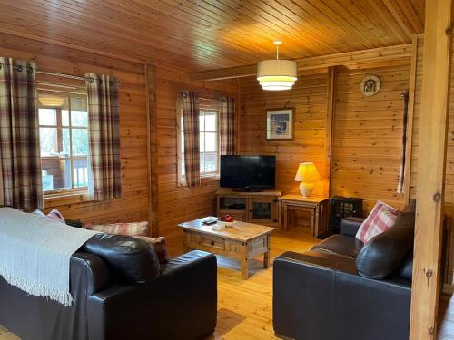 a living room with a couch and a tv at Sun Rise Lodge No 10 - Hw7655 in Llanbedr