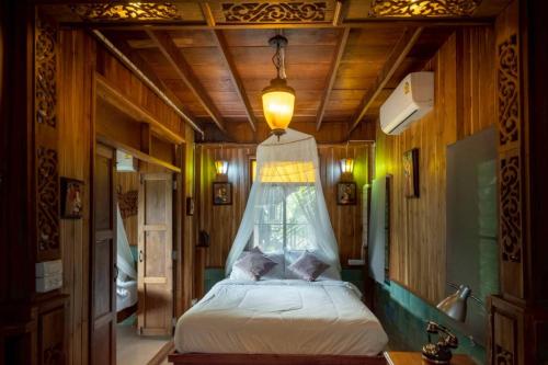 a bedroom with a bed with a mosquito net at Blue Sky Monjam in Chiang Mai