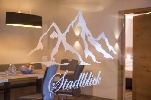 a dining room with a table with a mountain decal on the wall at Aparthotel AlpTirol in Kaltenbach