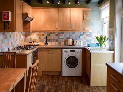 a kitchen with a washer and dryer in it at Puzzle Corner in Sandsend