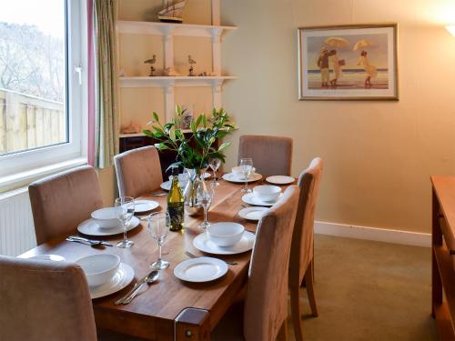 a wooden table with chairs and a dining room at Puzzle Corner in Sandsend
