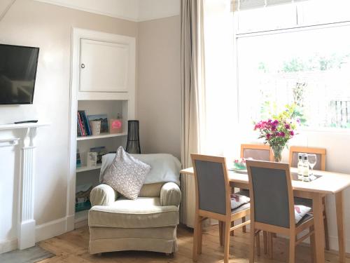 a living room with a table and a chair and a dining room at The Wee Cottage - Uk42919 in Dunfermline