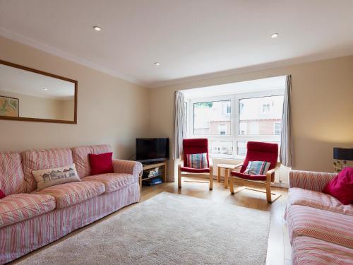 a living room with a couch and two chairs and a tv at Oakridge in Salcombe