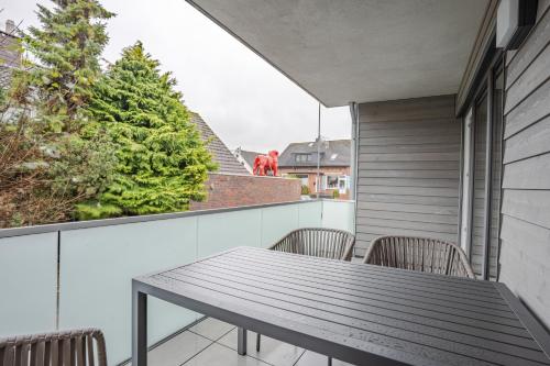 a table and chairs on a balcony with a christmas tree at Nr 301 - Apartmenthaus "Harleblick" in Carolinensiel