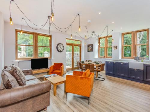 a living room with a couch and a table at Gardeners Cottage in Huntly