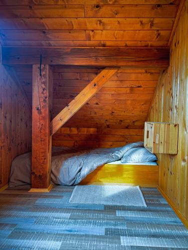 a room with a bed in a wooden cabin at Cozy Winehouse - Remote Vineyard Escape in Podčetrtek