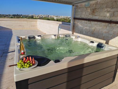 a bath tub with a bowl of fruit and a bottle of wine at Tenuta Ulivi in Putignano