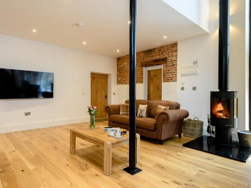 a living room with a couch and a fireplace at Pipistrelle Barn in North Walsham