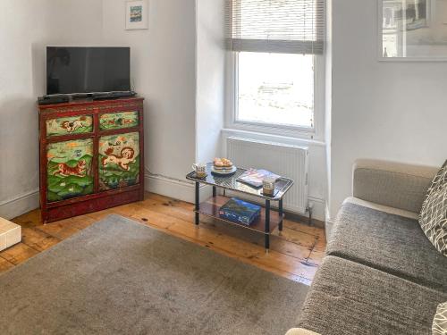 a living room with a tv and a table at Nautilus in St Ives