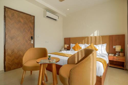 a hotel room with a bed with two chairs and a table at Hotel Tranquil Airport Road Sector 66 Mohali Chandigarh in Mohali