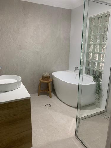 a bathroom with a tub and a sink and a shower at Se-Ayr BnB at Lighthouse in Port Macquarie