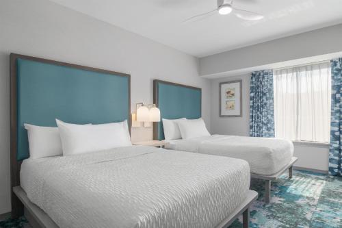 a hotel room with two beds and two windows at Homewood Suites Williamsburg in Williamsburg