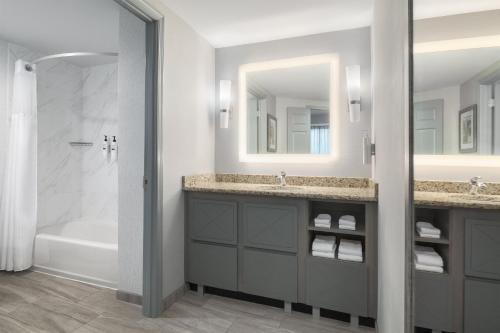 a bathroom with two sinks and a tub and a shower at Homewood Suites Williamsburg in Williamsburg