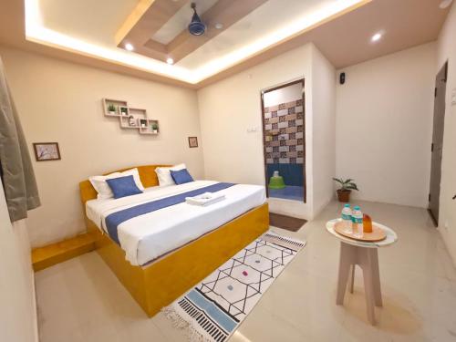 a bedroom with a bed and a table in it at Vijaya Lodge in Vadalūr