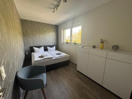 a bedroom with a bed and a chair and a window at Stilapartment Loft #Whirlpool saisonal in Wernigerode