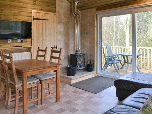 a living room with a table and a wood stove at Treehouse Cabin in Westward
