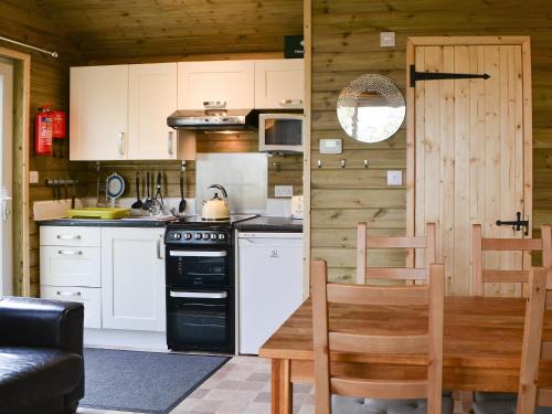 a kitchen with a table and a stove top oven at Treehouse Cabin in Westward