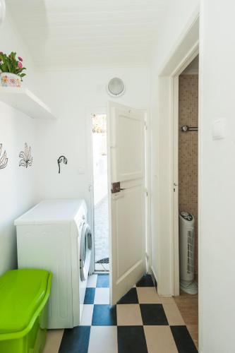 a laundry room with a washing machine and a checkered floor at Castelo Terrace in Lisbon