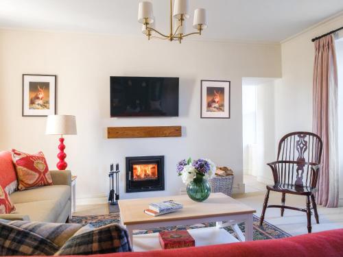 a living room with a couch and a fireplace at West Skeroblin in Campbeltown